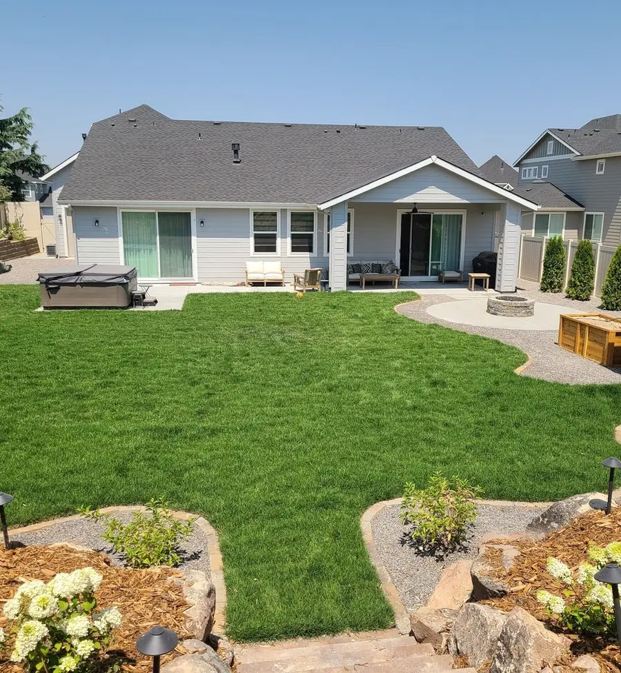 A new lawn, planting beds and a patio behind a newly built home
