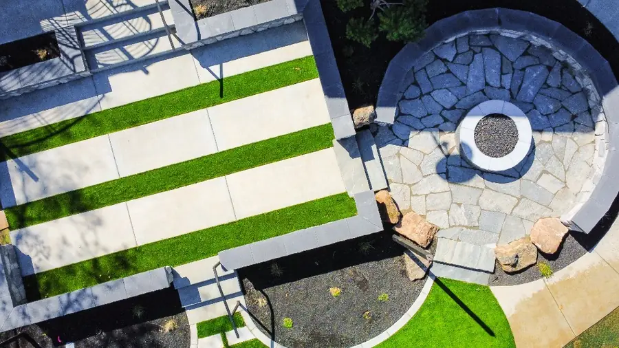 Looking down on a round stone fire terrace and striped turf terraces