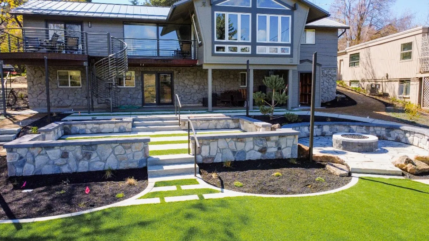 A foothills home above terraced lawns, stone walls and wide concrete steps
