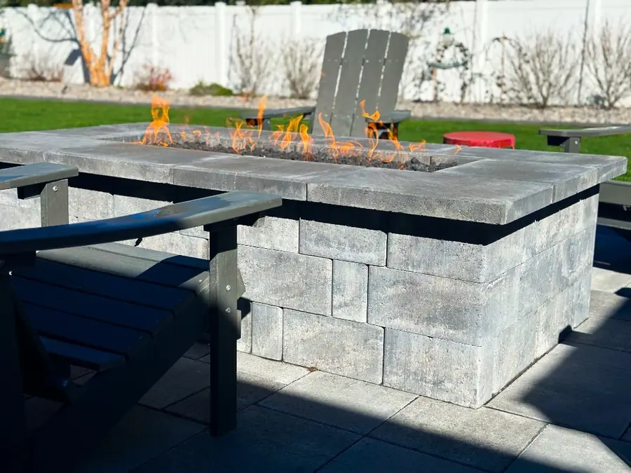 A built-in gas fire table of stacked block on a new paver terrace