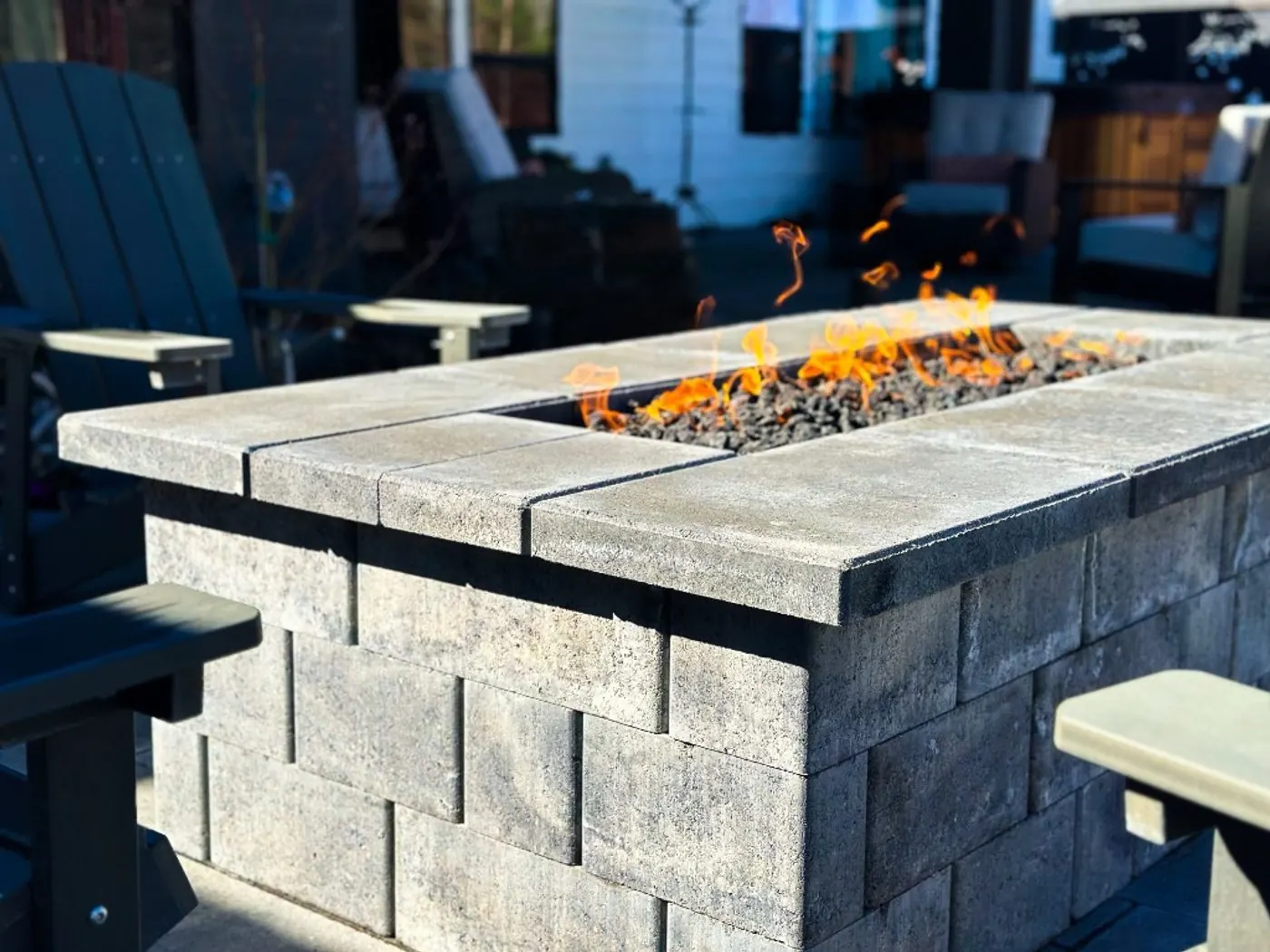 Close-up of the long flame rising from black lava rock between the fire table's concrete cap pieces