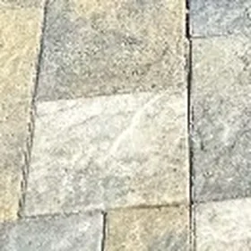 Close-up of tumbled concrete pavers in sand and gray tones